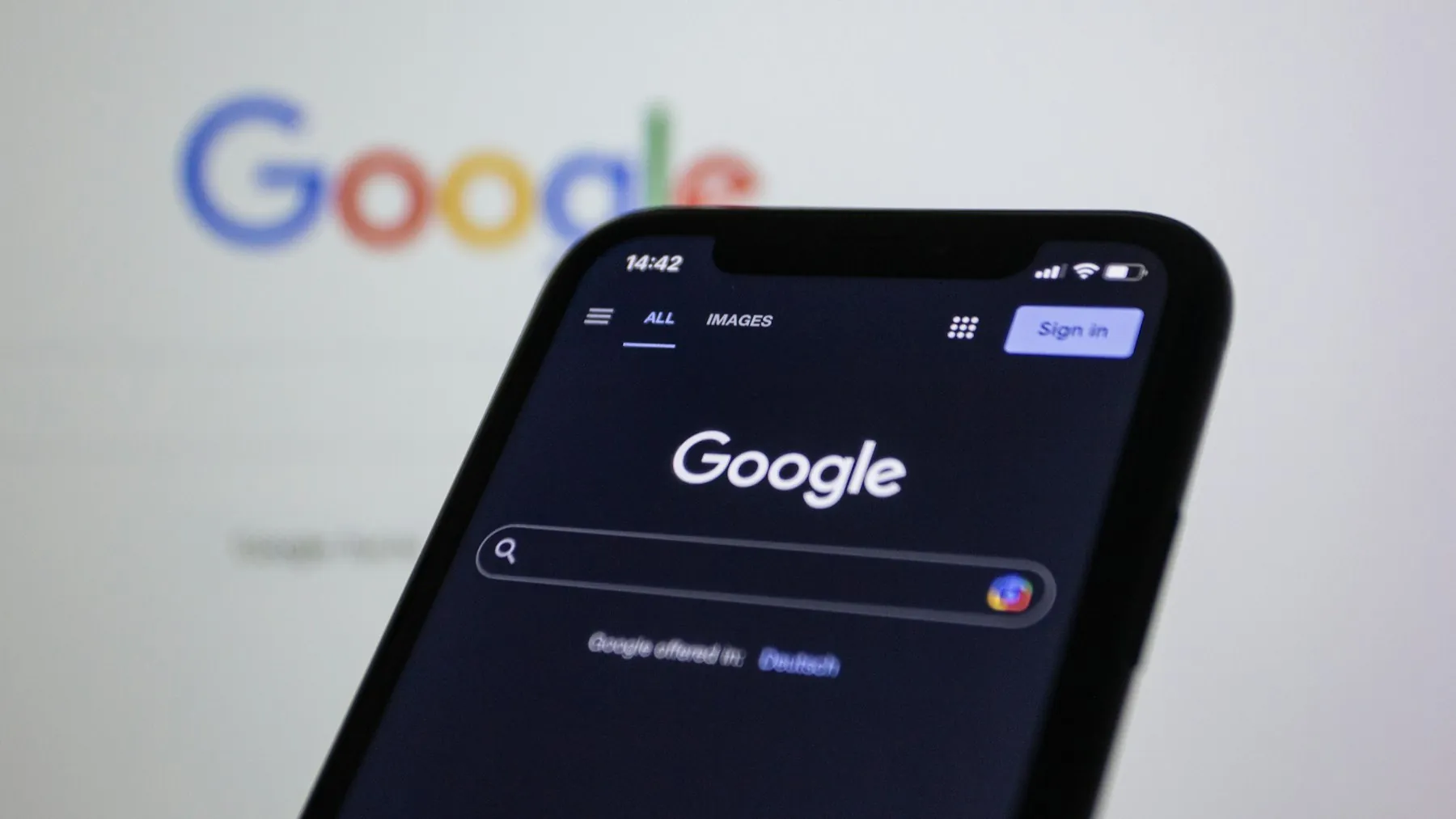 A phone held in front of the Google logo, as Google AI Mode reaches Gulf search