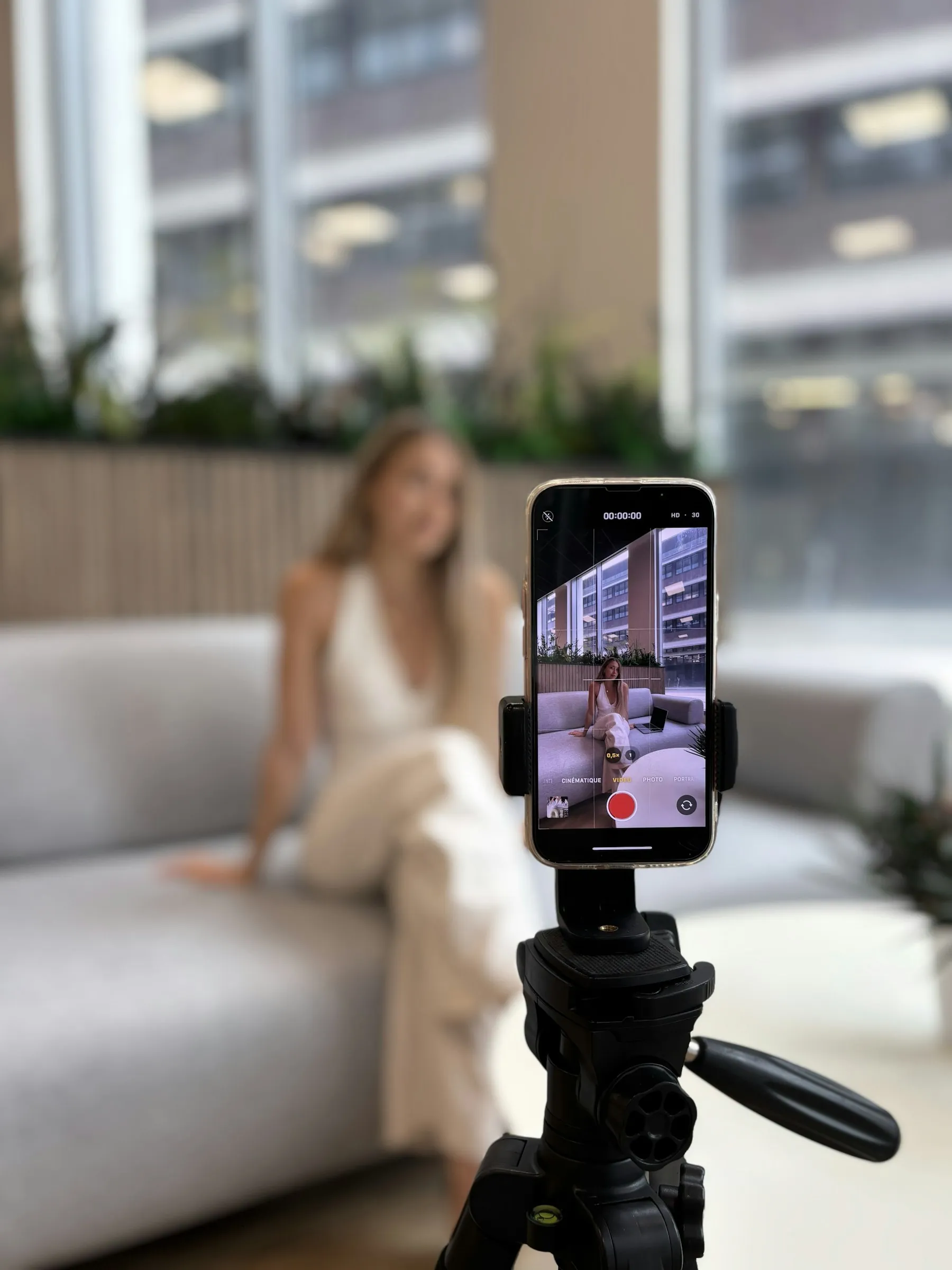 A woman recording herself on a smartphone on a tripod, a typical influencer marketing set-up