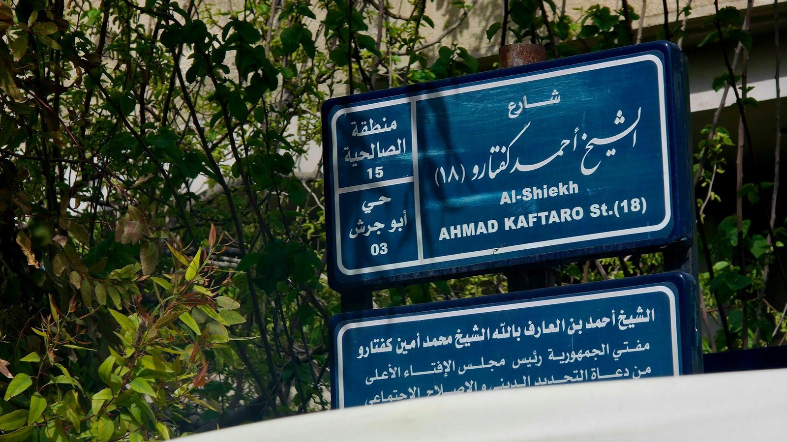 Street signs in Arabic and English with building names