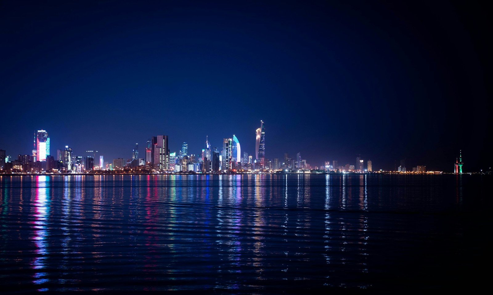 City skyline illuminated at night with water reflections