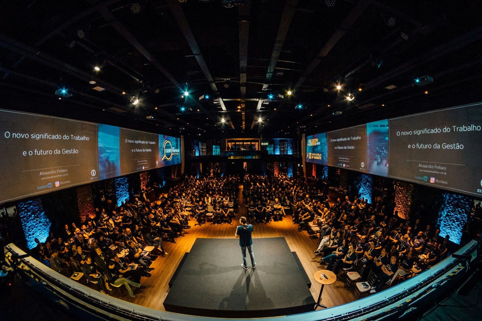 Speaker on stage addressing a large audience