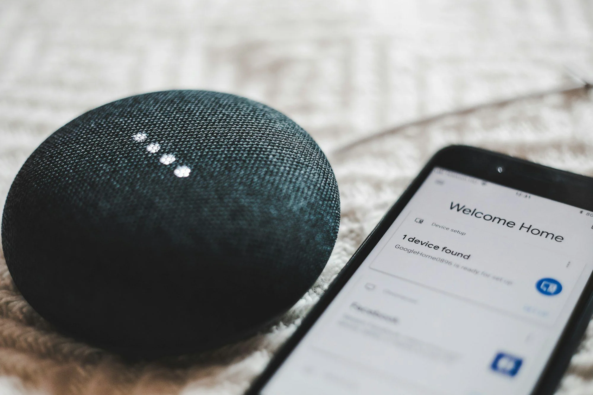 A smart speaker beside a smartphone, representing Arabic voice search in the Gulf