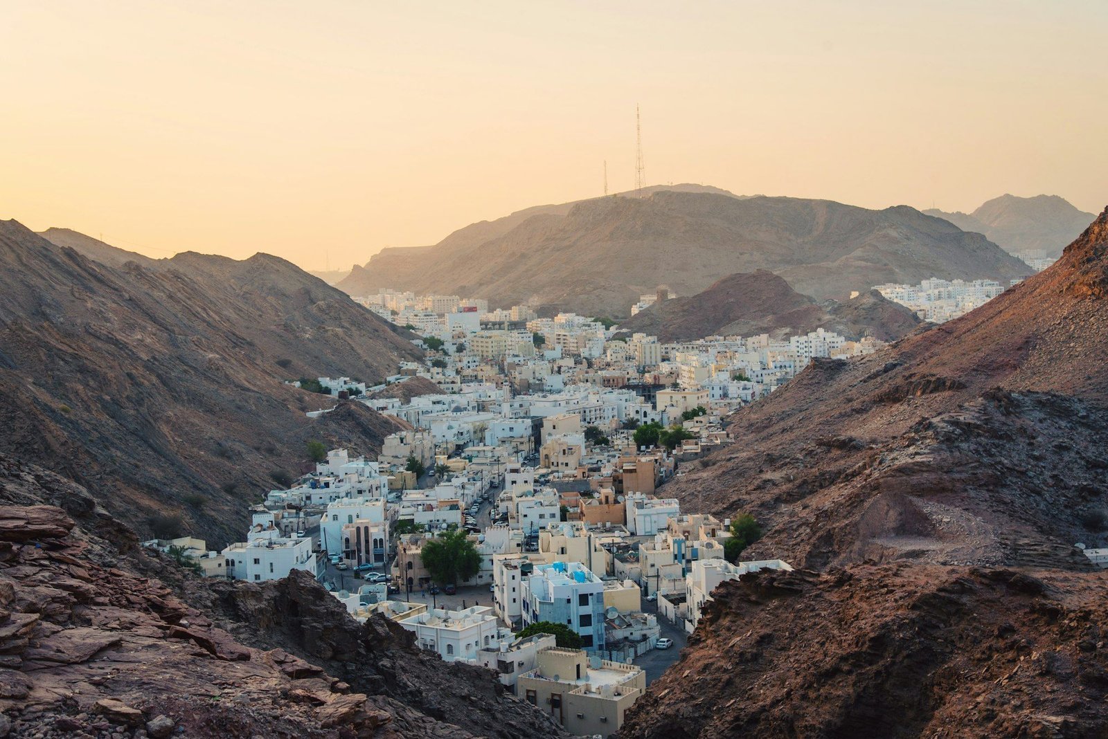 Aerial view of white buildings near rocky cliffs on the Oman coast