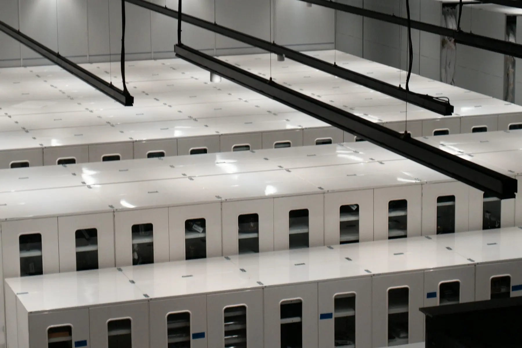 Rows of white server cabinets in a modern data centre, where AI crawlers request web pages